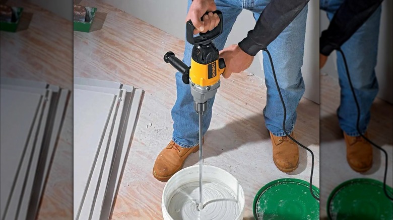 Person using DeWalt 9 Amp ½-inch Spade Handle Drill to mix concrete