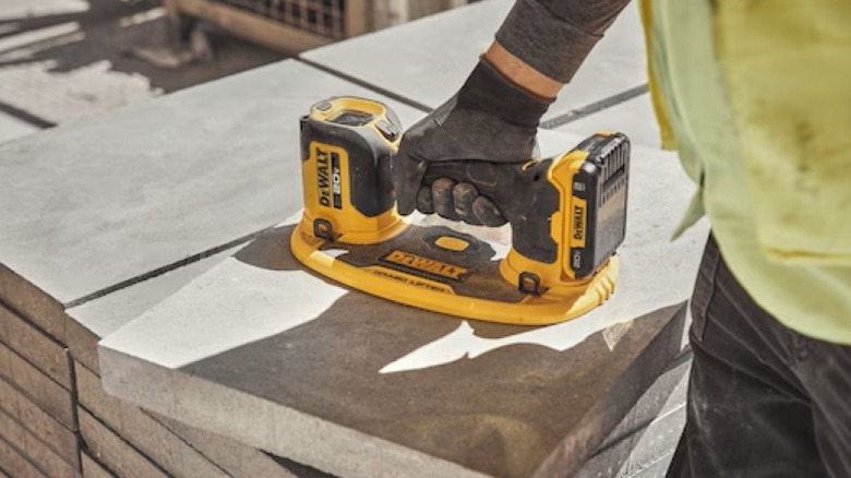 Person using grab tool on concrete block