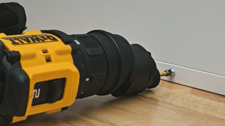 person using drill with offset head to secure screw