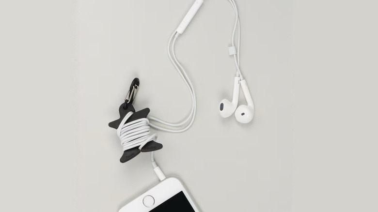 Earbuds cord wrapped around Nite Ize Cord Supervisor.