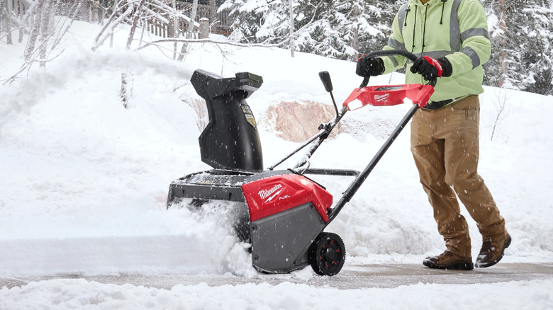 Milwaukee snow blower pushed by a man