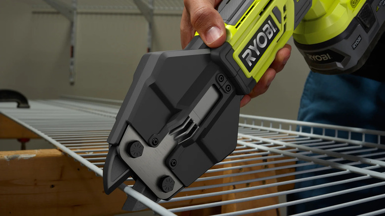 Person using bolt cutter on wire shelving