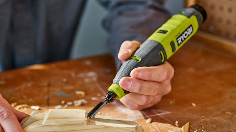 Person using power carver to shape wood