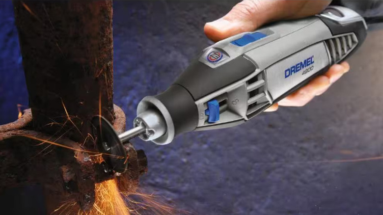 person cutting through bolt with Dremel tool
