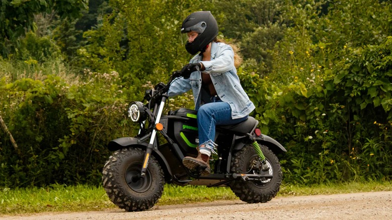 Rider driving Greenworks 60V Stealth Electric Mini Bike down a dirt road