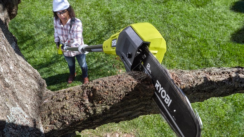 Person using pole saw