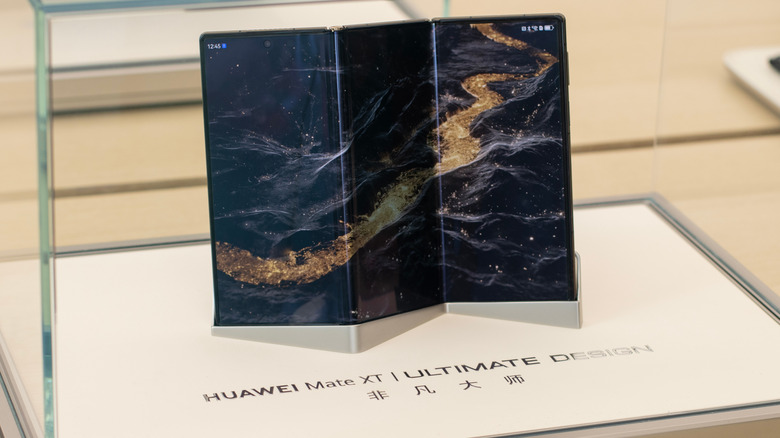Huawei Mate XT Ultimate Design unfolded and presented in a glass case