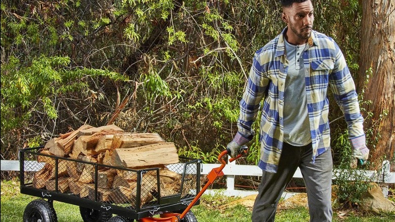 Man pulling cart with wood