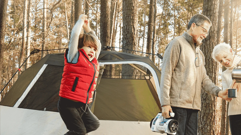 family camping with man holding inflator