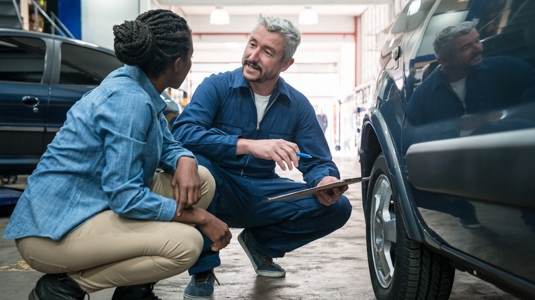 Auto mechanic talking to customer
