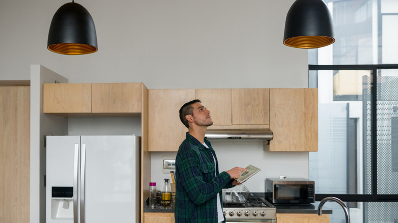 A person using an iPad to control all the smart gadgets in his kitchen