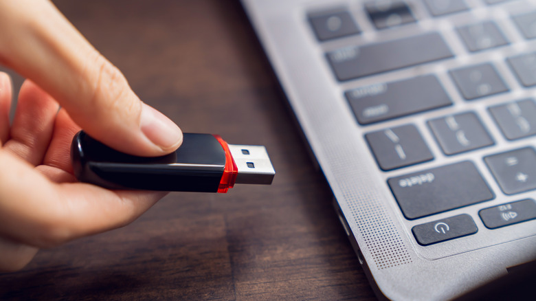 Hand inserting USB drive laptop