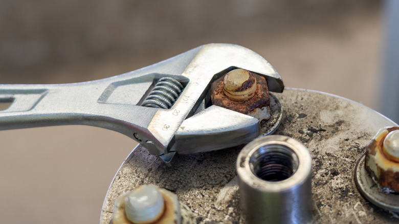 Adjustable wrench on a rusted bolt
