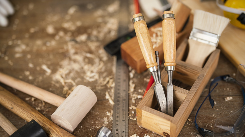 Many woodworking hand tools on a bench