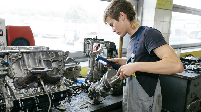 Mechanic inspecting crankshaft