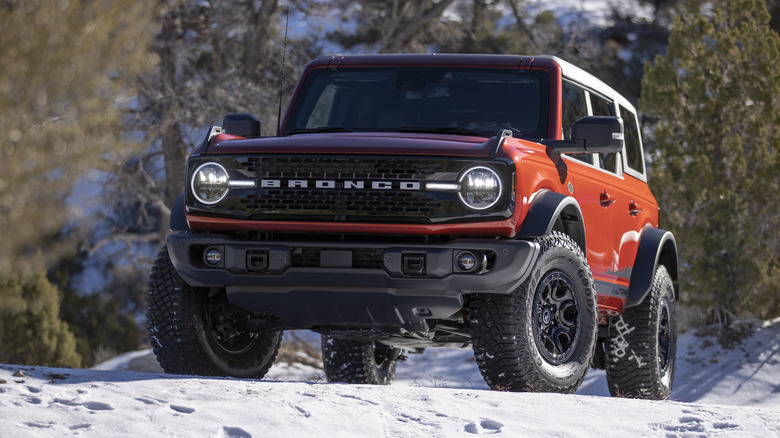 An orange Ford Bronco on a snow-covered hill