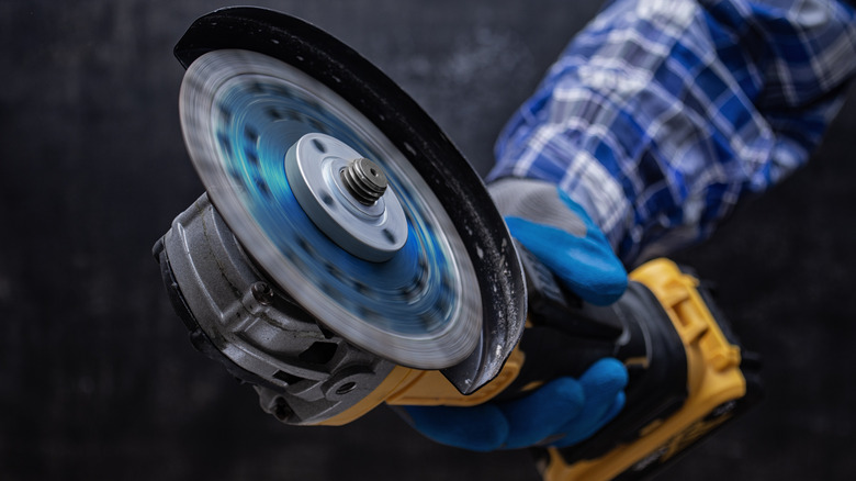 cluseup of a gloved hand holding an angle grinder