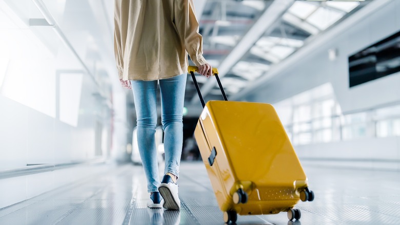 person pulling luggage through airport