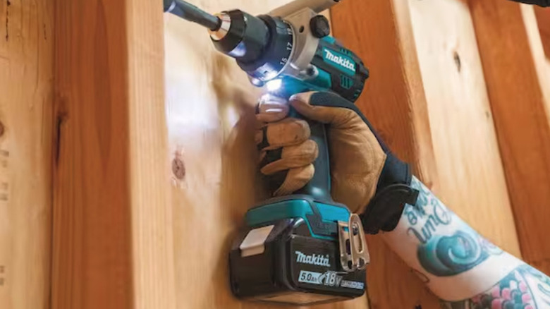 Makita drill being used on stud