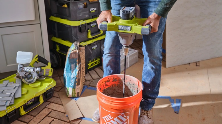 Ryobi 18V One+ HP ½-inch Mud Mixer in use with other Ryobi gear around it