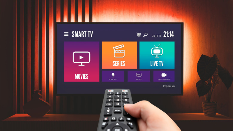A man using the remote of a smart TV to explore its features