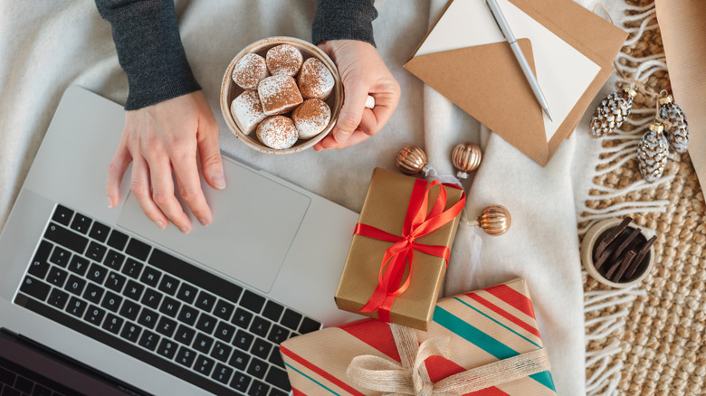 woman using laptop with gifts