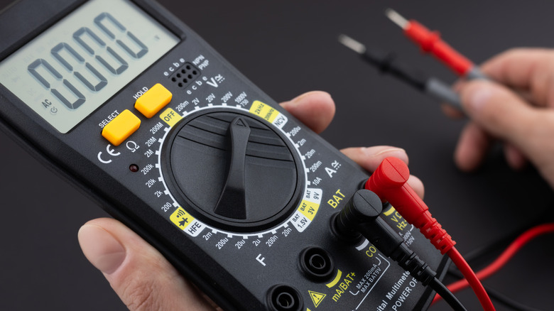 A person using a multimeter