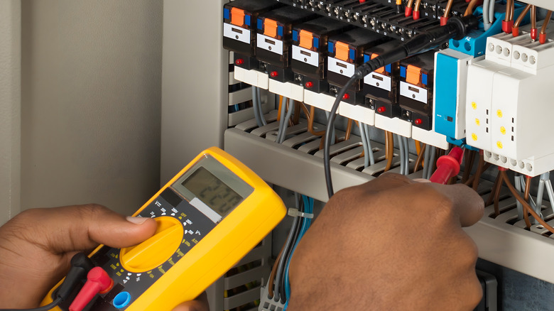 man using multimeter to test fuses