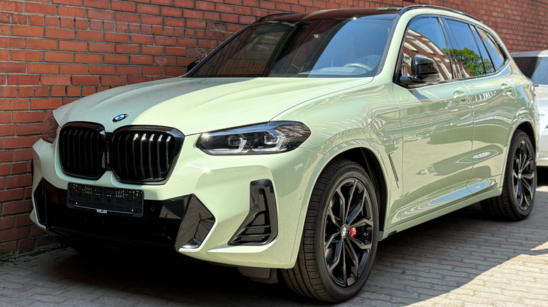 BMW X3 parked by a brick wall