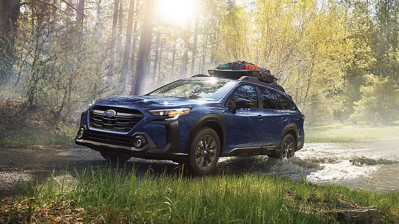 Blue Subaru Outback offroading in the woods