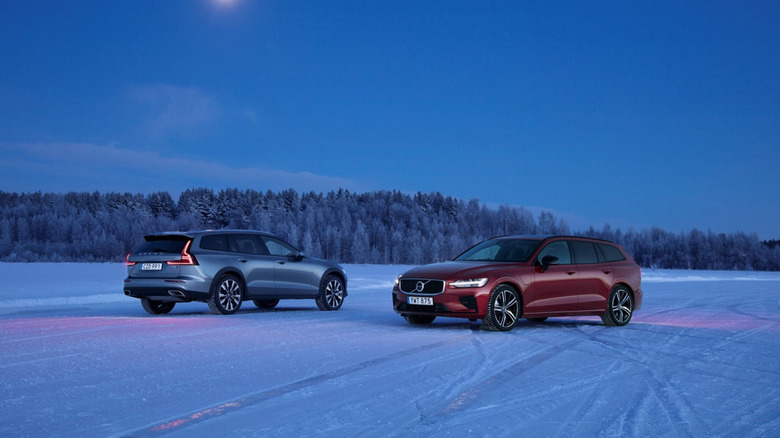 A Blue and A Red 2020 Volvo V60 on an ice covered road against the afternoon sun.