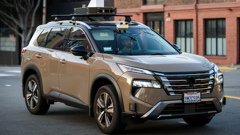 An unmarked Nissan SUV driving down a road