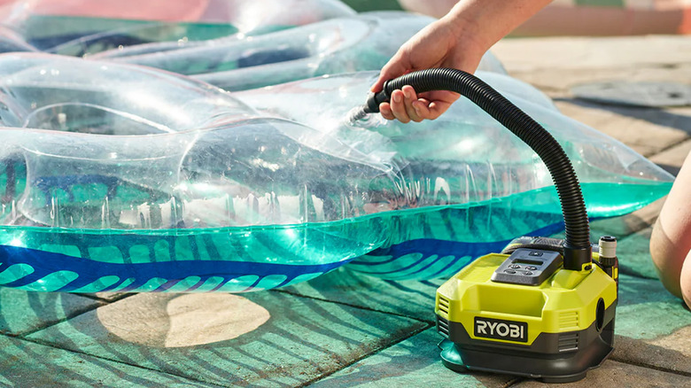 A person inflating a pool toy with a Ryobi inflator
