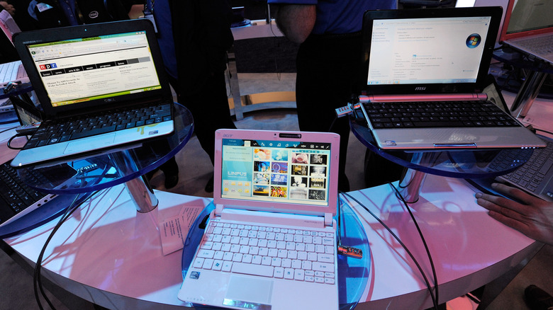 Netbooks sitting on a table at a convention running Windows