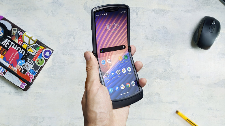 Motorola Razr 2 in hand above desk