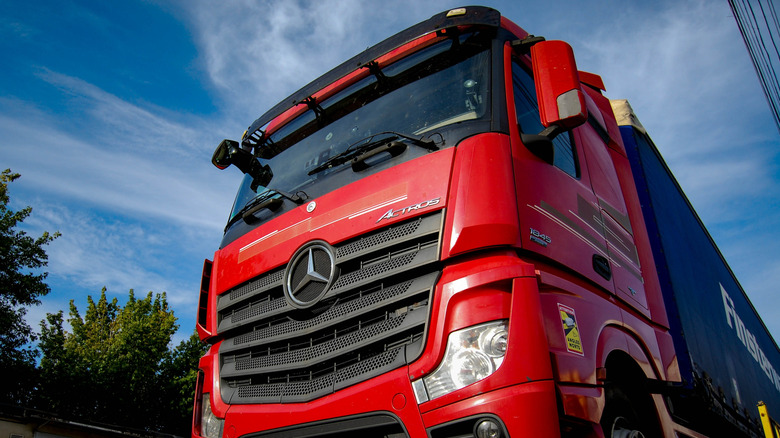 Red Mercedes-Benz Actros semi-truck seen from low left front