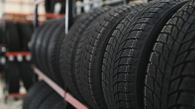 A close up shot of winter tires sitting on a tire rack