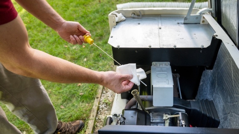 man checking oil level in generator