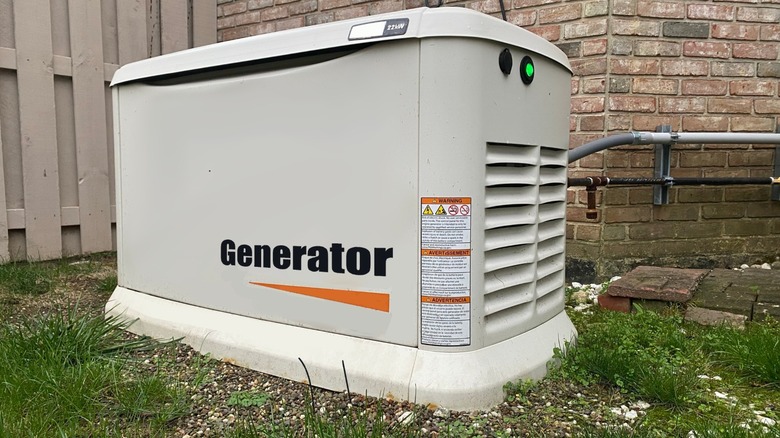 A standby generator in front of a brick wall
