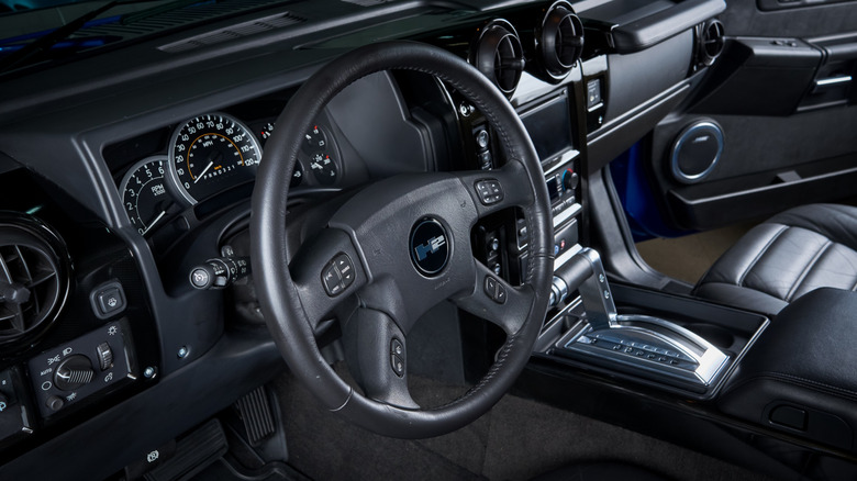 The interior of the Hummer H2, dark background, driver's side