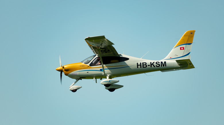 A Tecnam P2010 aircraft in the air, approaching a runway.
