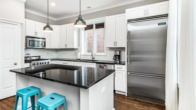 A modern white kitchen setup with white cabinets fitted with Viking appliances