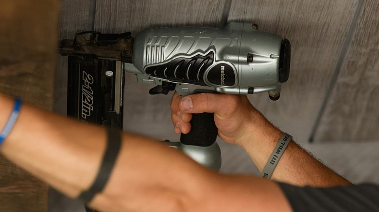 Person using air brad nailer