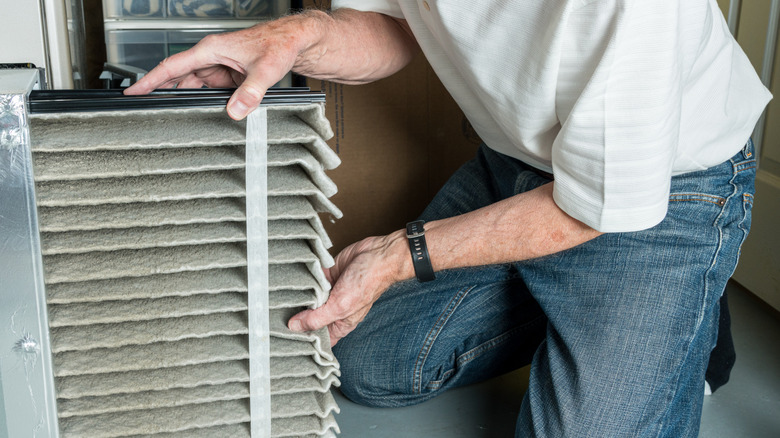 A person changing the dust filter of an HVAC unit