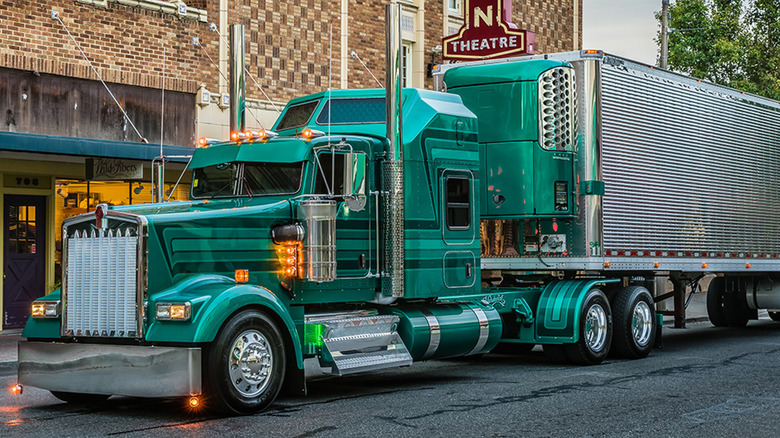 A Kenworth W900L parked in front of a theater