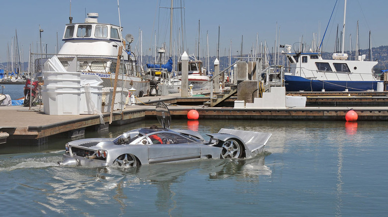 Project Sea Lion amphibious prototype car floating in a marina, showcasing its futuristic design and dual land-water functionality.