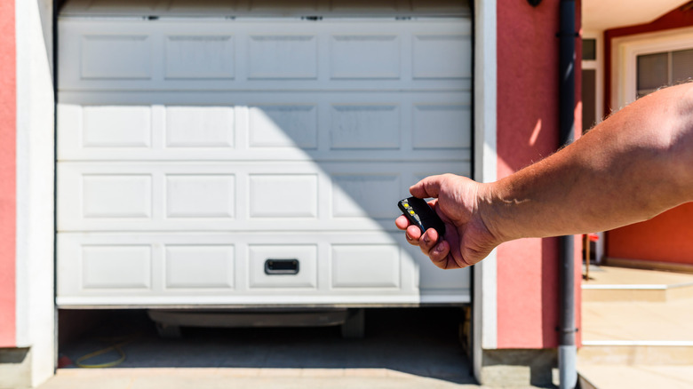 Man opening garage door with remote