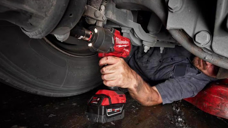 A mechanic using a Milwaukee impact wrench