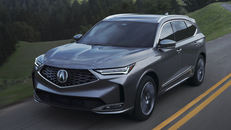 Front 3/4 view of Acura MDX SUV in forested setting