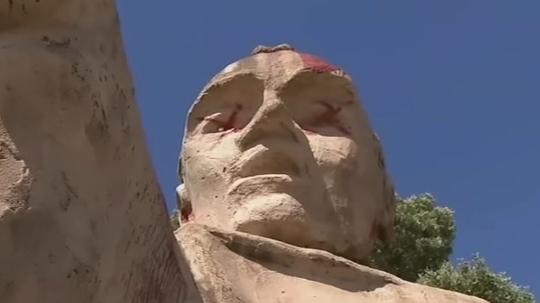 Close up of graffitied Junípero Serra statue